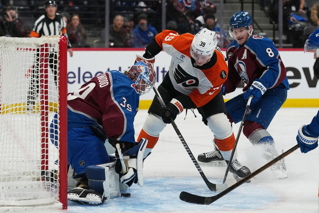 Philadelphia Flyers right wing Matvei Michkov, center, puts a shot on Colorado Avalanche goaltender MacKenzie Blackwood, left, as Cale Makar covers in the second period of an NHL hockey game Friday, Jan. 23, 2026, in Denver. (AP Photo/David Zalubowski)
