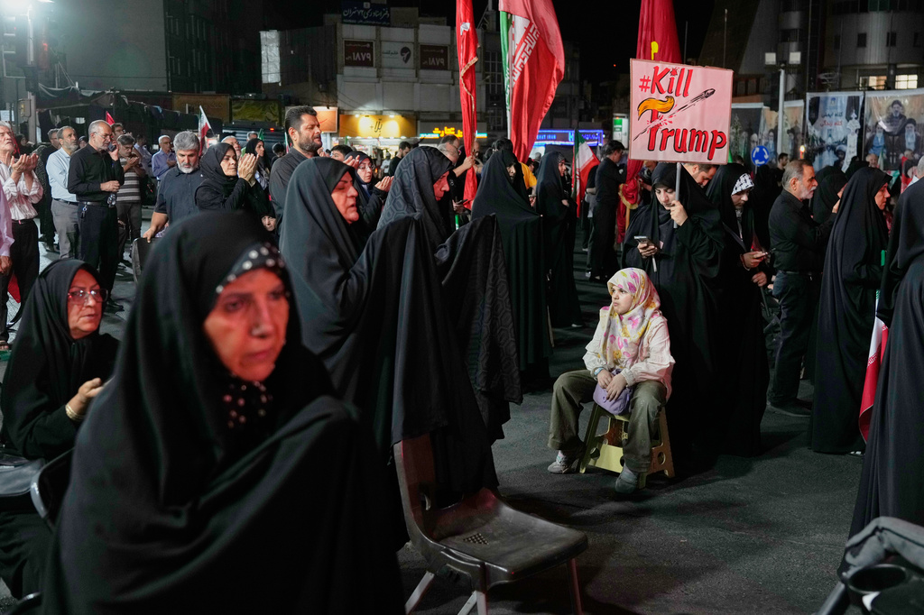Women gather during a pro-government rally as one holds a sign reading in English, "Kill Trump," in Tehran, Friday, July 17, 2026. (AP Photo/Vahid Salemi)