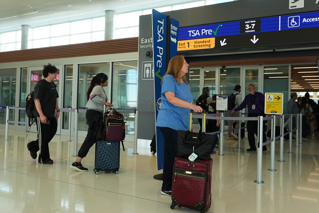 Travellers line up at the east security checkpoint in Denver International Airport Friday, March 20, 2026, in Denver. (AP Photo/David Zalubowski)
