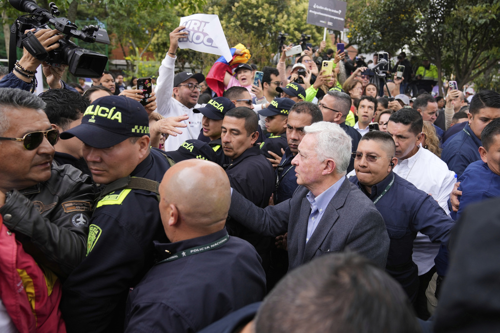 Former Colombian President Alvaro Uribe greets supporters during a visit to the site where presidential hopeful and Sen. Miguel Uribe Turbay was fatally shot during a political rally in Bogota, Colombia, Saturday, Aug. 23, 2025. (AP Photo/Fernando Vergara)