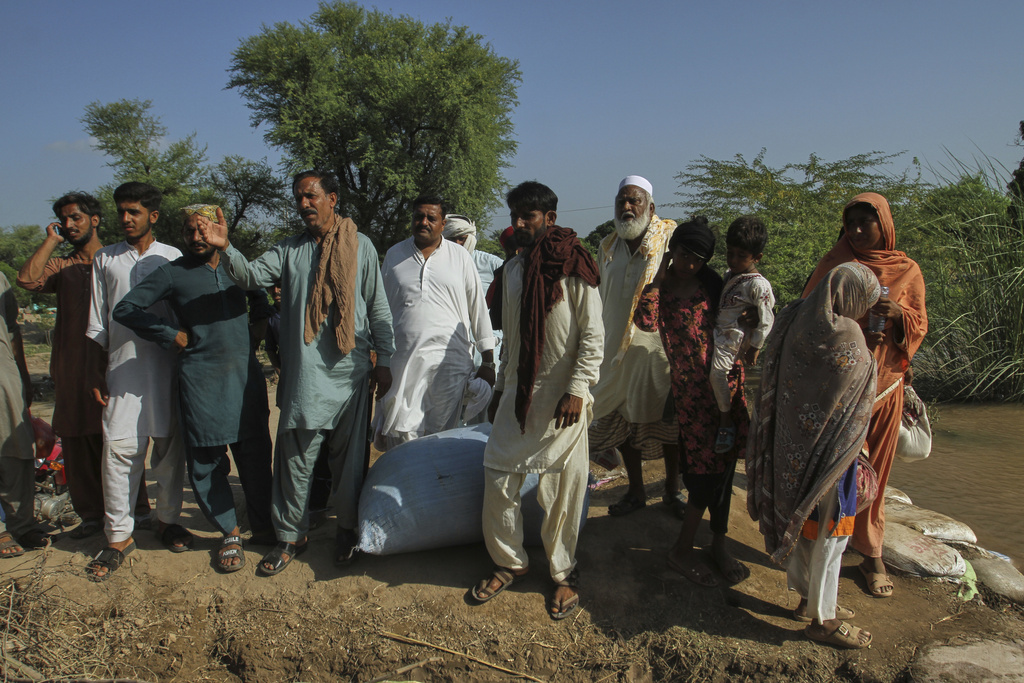 Villagers look to a rescue boat arriving to evacuate them from a flooded area in Muhammad Pur Ghotta in Multan district, Pakistan, Thursday, Sept. 11, 2025. (AP Photo/Asim Tanveer)