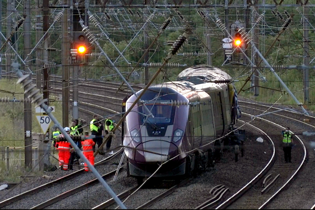 Emergency personnel work on a train on the tracks outside Bedford, England, after a train from Corby to London St. Pancras and another from Nottingham to London St. Pancras, collided on Friday June 19, 2026. (Jamie Lashmar/PA via AP)