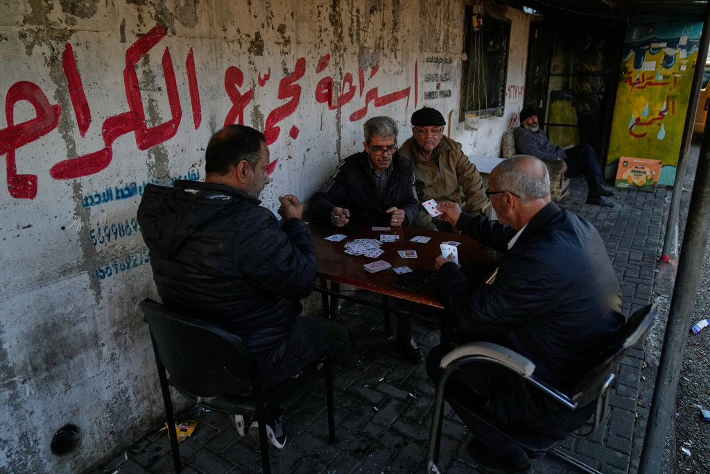 Palestinian public transportation drivers play cards while they wait for passengers at the main bus station, in the West Bank city of Tulkarem Sunday, Jan. 18, 2026. (AP Photo/Nasser Nasser)