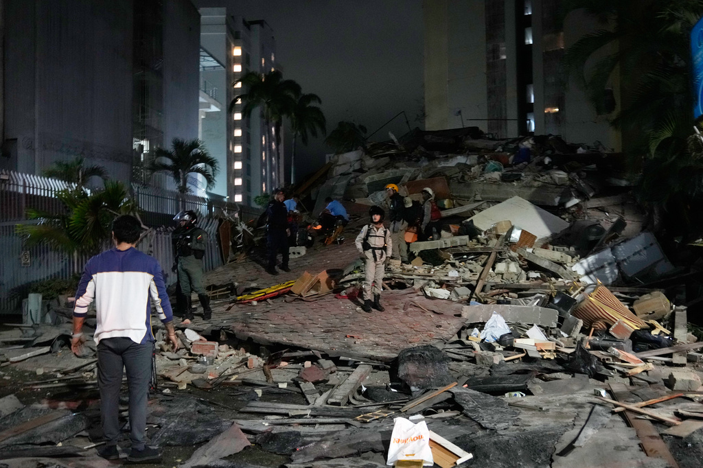 People walk amid debris after an earthquake in Caracas, Venezuela, Wednesday, June 24, 2026. (AP Photo/Ariana Cubillos)