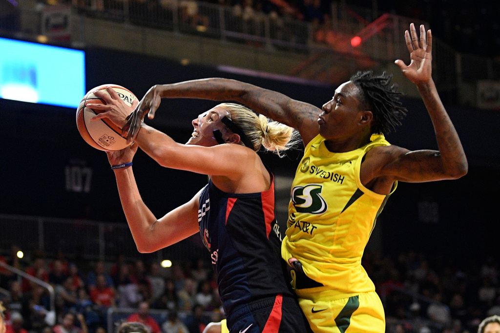 FILE - Washington Mystics forward Elena Delle Donne, left, goes to the basket against Seattle Storm forward Natasha Howard during the second half of a WNBA basketball game, Aug. 14, 2019, in Washington. (AP Photo/Nick Wass, File)