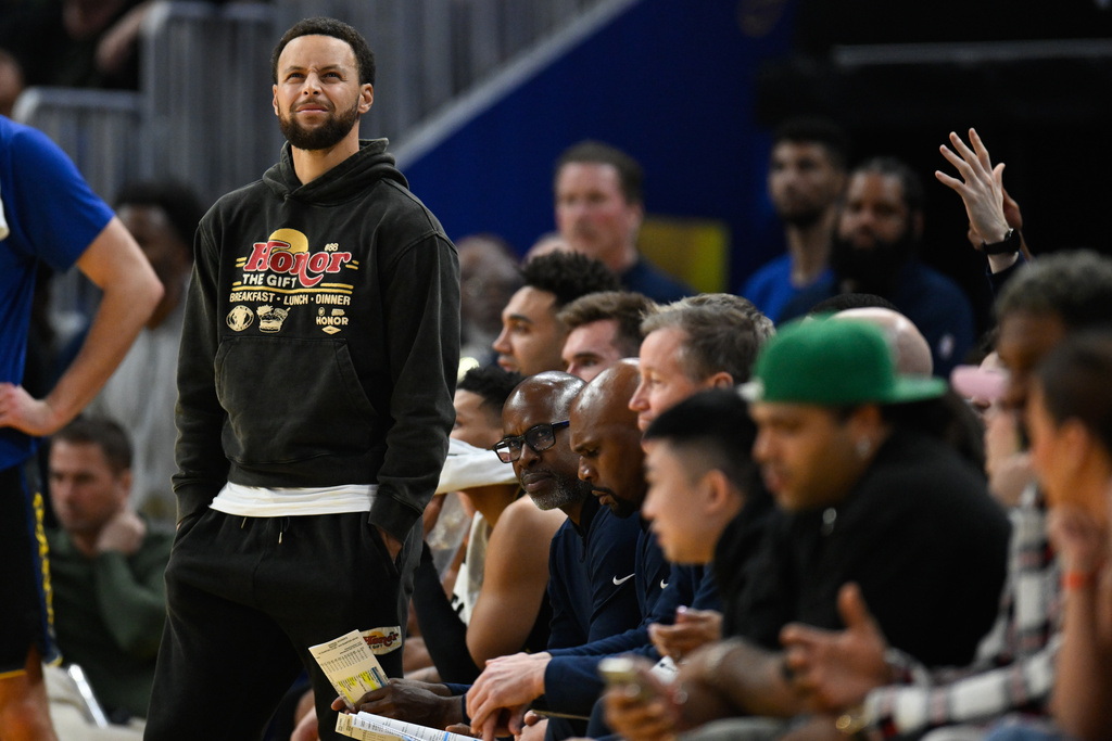 Golden State Warriors guard Stephen Curry stands by the team bench against the Philadelphia 76ers during the first half of an NBA basketball game Tuesday, Feb. 3, 2026, in San Francisco. (AP Photo/Eakin Howard)