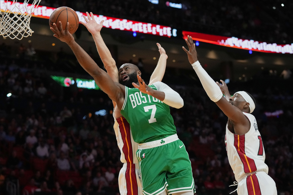 Boston Celtics guard Jaylen Brown (7) goes tot he basket as Miami Heat guard Pelle Larsson, left, and center Bam Adebayo, right, defend during the first half of an NBA basketball game, Wednesday, April 1, 2026, in Miami. (AP Photo/Lynne Sladky)