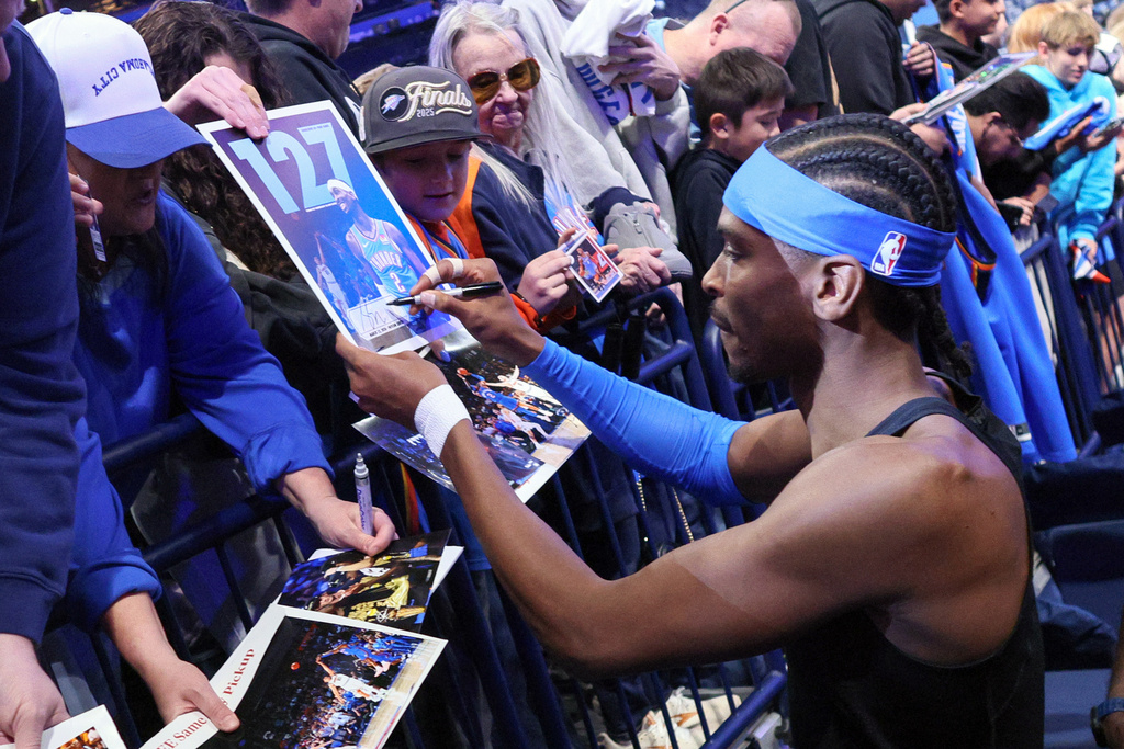 Oklahoma City Thunder guard Shai Gilgeous-Alexander signs autographs before an NBA basketball game against the Boston Celtics, Thursday, March 12, 2026, in Oklahoma City. (AP Photo/Nate Billings)