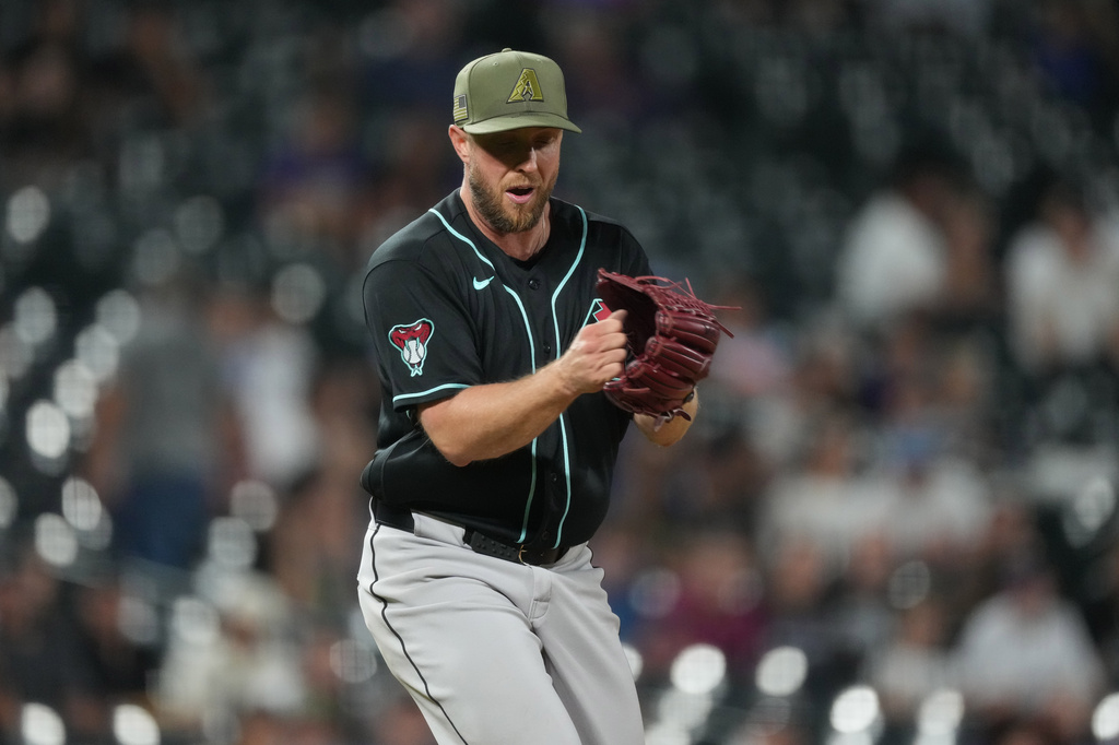 Arizona Diamondbacks starting pitcher Merrill Kelly reacts after striking out Colorado Rockies' TJ Rumfield to end the ninth inning of a baseball game Friday, May 15, 2026, in Denver. (AP Photo/David Zalubowski)