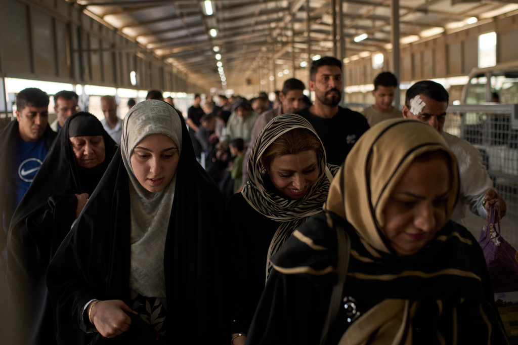 People who arrived from Iran cross the Shalamcheh border crossing between Iran and Iraq, near Basra, Iraq, Sunday, March 29, 2026. (AP Photo/Leo Correa)