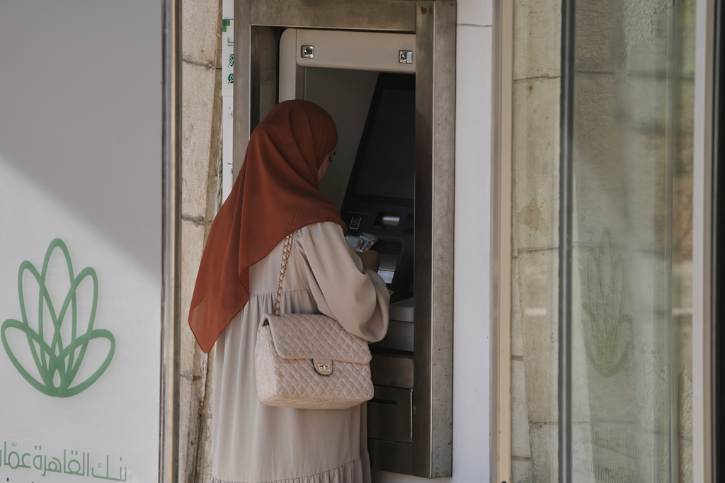 A Palestinian woman withdraws money from an ATM in the West Bank city of Bethlehem, Tuesday, July 7, 2026. (AP Photo/Mahmoud Illean)
