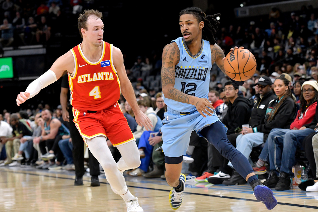 Memphis Grizzlies guard Ja Morant (12) handles the ball against Atlanta Hawks guard Luke Kennard (4) in the second half of an NBA basketball game Wednesday, Jan. 21, 2026, in Memphis, Tenn. (AP Photo/Brandon Dill)