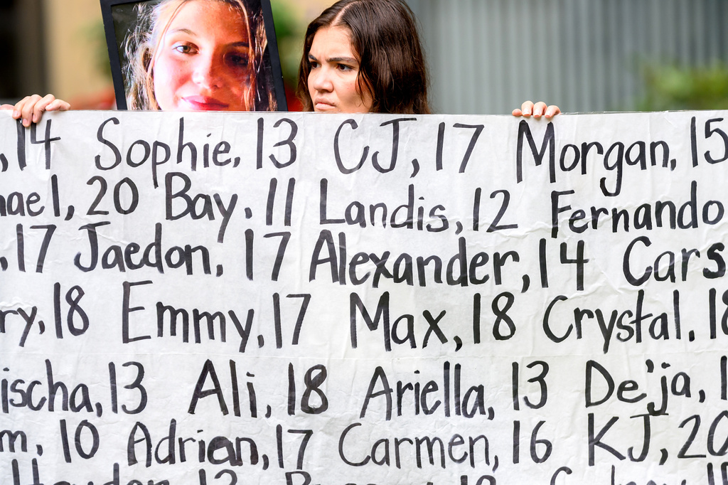 Olivia Konar holds a banner with names of young people who advocates say died as a result of social media outside the Ronald V. Dellums Federal Building and U.S. Courthouse on Tuesday, Aug. 18, 2026, in Oakland, Calif. Her sister Coco Konar, pictured at left, died in 2022 when she was 17. (AP Photo/Noah Berger)