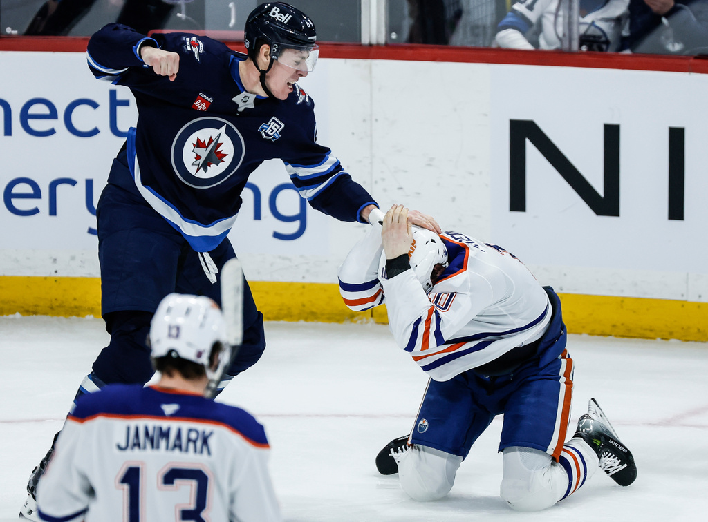 Edmonton Oilers' Trent Frederic (10) protects himself as he expects a punch from Winnipeg Jets' Logan Stanley (64) during second period NHL action in Winnipeg, Manitoba, Thursday, Jan. 8, 2026. (John Woods/The Canadian Press via AP)