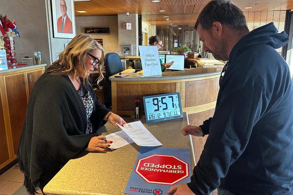 Chrissy Peters, director of elections for the Missouri secretary of state, approves the paperwork showing that petition signatures were submitted Tuesday, Dec. 9, 2025, in Jefferson City by People Not Politicians Executive Director Richard von Glahn calling for a referendum election on new U.S. House districts passed by the Missouri legislature. (AP Photo/David A. Lieb)