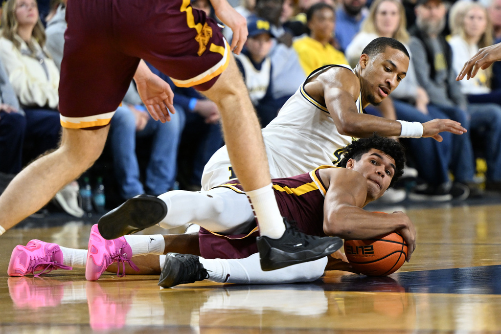 Minnesota guard Isaac Asuma (1) grabs a loose ball away from Michigan guard Nimari Burnett (4) in the first half of an NCAA college basketball game in Ann Arbor, Mich., Tuesday, Feb. 24, 2026. (AP Photo/Lon Horwedel)