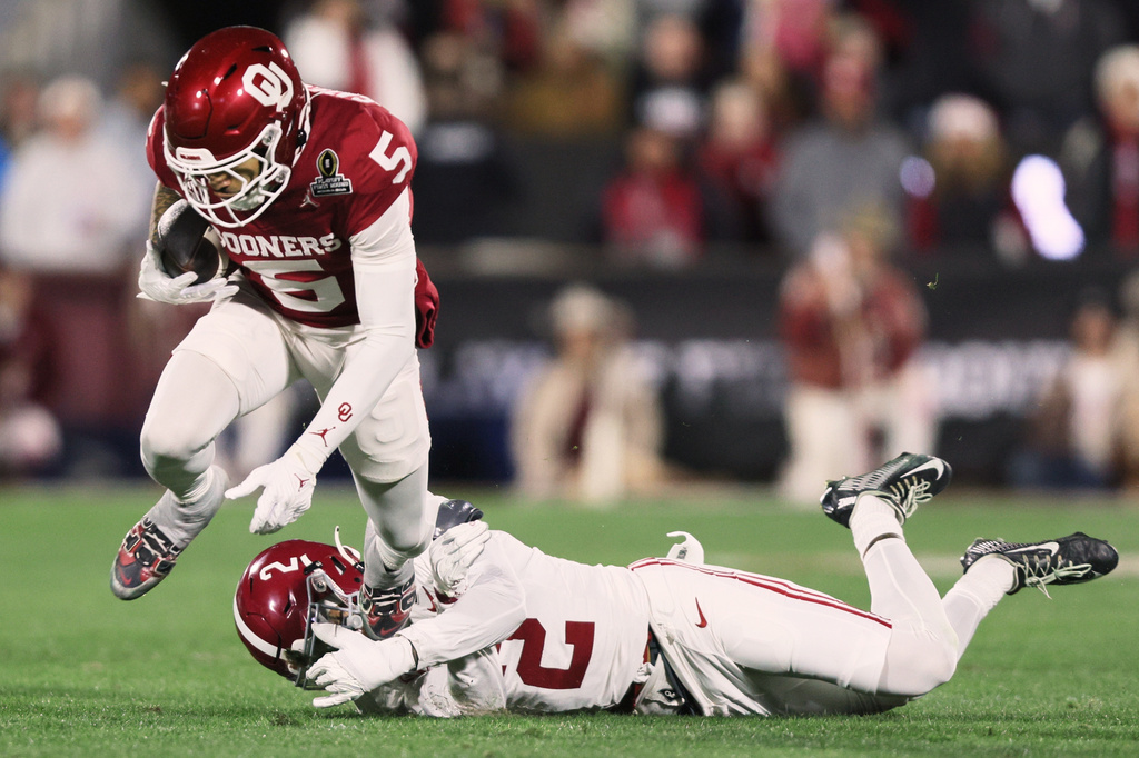 FILE - Oklahoma wide receiver Isaiah Sategna III (5) runs against Alabama defensive back Zabien Brown (2) during the first half in the first round of an NCAA College Football Playoff game, Friday, Dec. 19, 2025, in Norman, Okla. (AP Photo/Nate Billings, File)