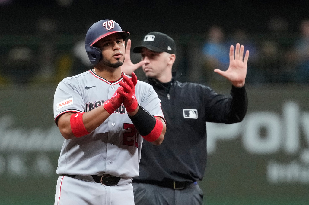 Washington Nationals' Keibert Ruiz, left, claps after hitting an RBI double during the ninth inning of a baseball game against the Milwaukee Brewers, Saturday, April 11, 2026, in Milwaukee. (AP Photo/Aaron Gash)