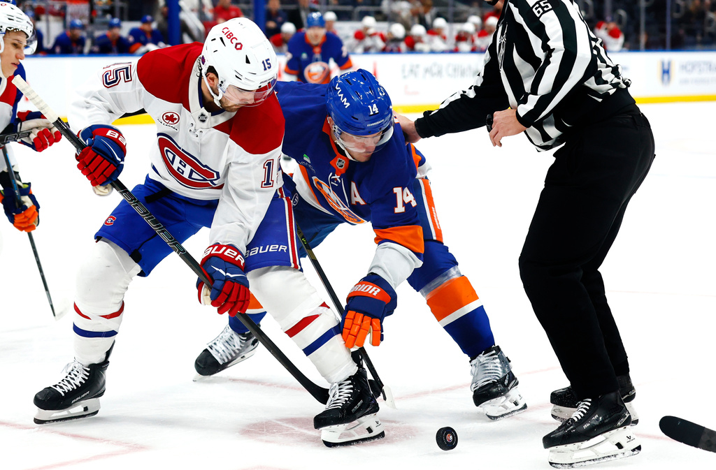 Montréal Canadiens center Alex Newhook (15) battles New York Islanders center Bo Horvat (14) for the puck during the second period of an NHL hockey game, Sunday, April 12, 2026, in Elmont, N.Y. (AP Photo/Noah K. Murray) CORRECTION: Corrects to Elmont, N.Y., not New York.
