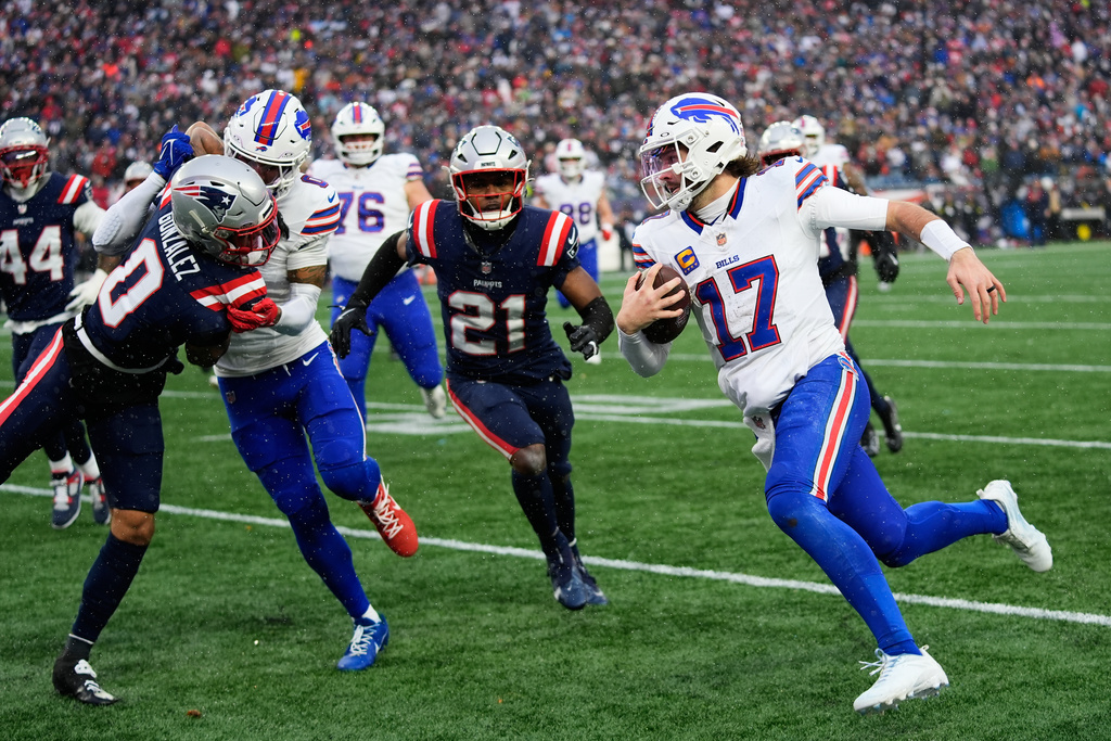 Buffalo Bills quarterback Josh Allen (17) runs against New England Patriots cornerback Christian Gonzalez (0) and safety Jaylinn Hawkins (21) during the second half of an NFL football game in Foxborough, Mass., Sunday, Dec. 14, 2025. (AP Photo/Robert F. Bukaty)