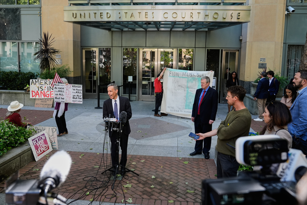 William Savitt, attorney representing OpenAI, center, speaks during a press conference outside the U.S. District Court in Oakland, Calif., Thursday, April 30, 2026. (AP Photo/Godofredo A. Vásquez)