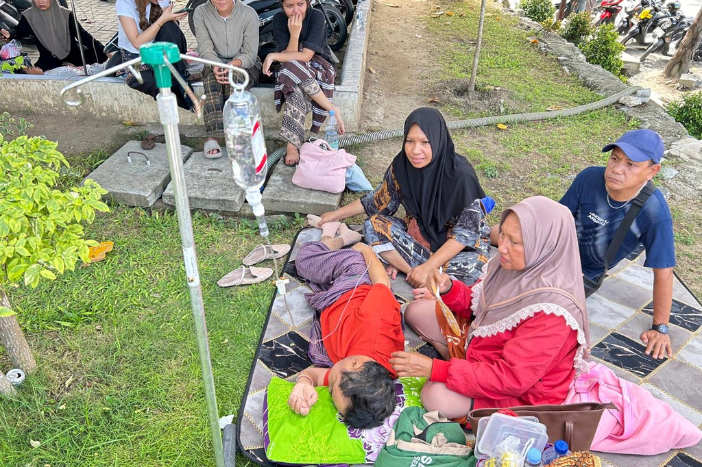Patients who were evacuated are seen outside of a local hospital following an earthquake in Palu, Central Sulawesi, Tuesday, June 16, 2026. (AP Photo/Taufan Bustan)