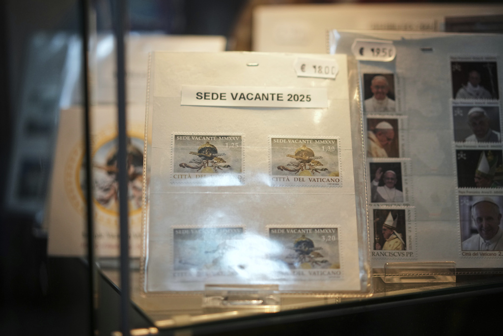 A series of 2025 Vatican Vacant Seat stamps are on display in the Filitalia stamps, coins, and souvenirs shop next to the Vatican walls, in Rome, Tuesday, April 29, 2025. (AP Photo/Andrew Medichini)