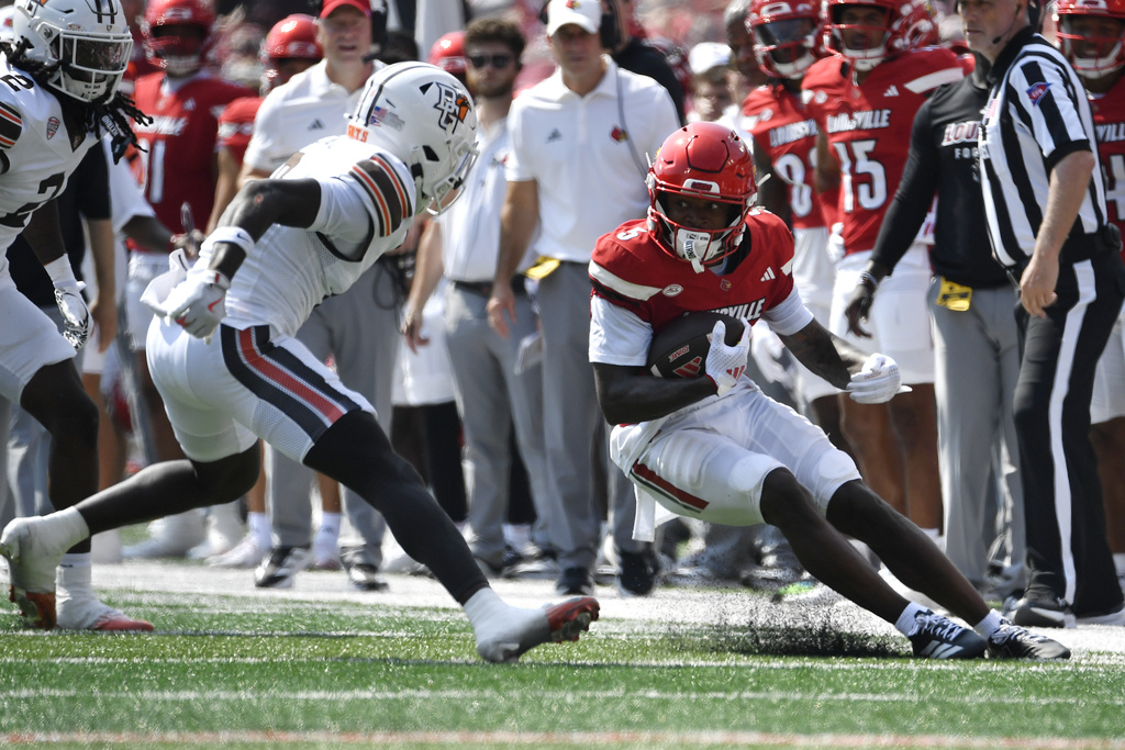Louisville wide receiver Caullin Lacy (5) attempts to avoid the tackle attempt by Bowling Green safety Kal-El Pascal (0) during the first half of an NCAA college football game in Louisville, Ky., Saturday, Sept. 20, 2025. (AP Photo/Timothy D. Easley)