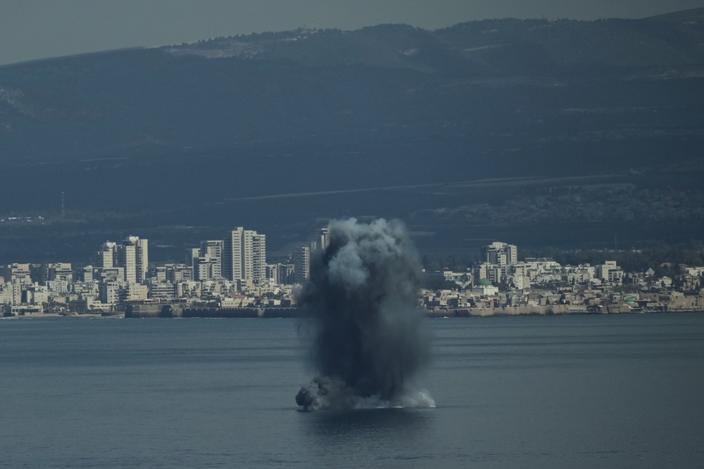 An incoming projectile explodes over the water as Israel issues a nationwide alert following its strikes on Iran, in Haifa Bay, northern Israel, Saturday, Feb. 28, 2026. (AP Photo/Leo Correa)