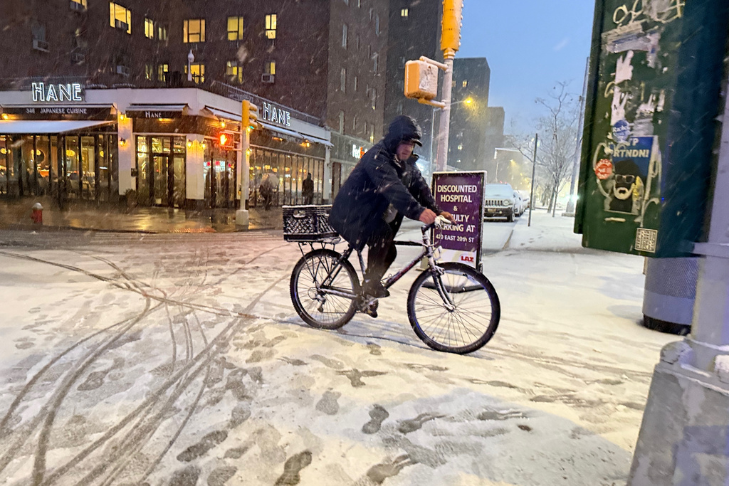 A man rides a bicycle in the beginning of an intense snowstorm by 20th Street and First Avenue, Sunday, Feb. 22, 2026, in New York. (AP Photo/Pamela Hassell)