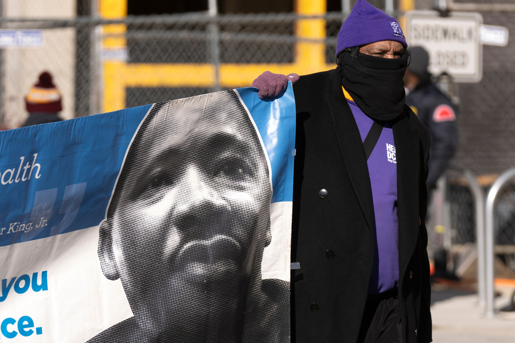 A participant carries a banner with an image of Martin Luther King, Jr., during the District of Columbia's annual Martin Luther King Day parade Monday, Jan. 19, 2026, in Washington. (AP Photo/Mark Schiefelbein)