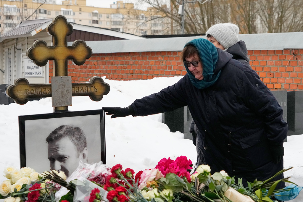 Late Russian opposition leader Alexei Navalny's mother Lyudmila Navalnaya touches his portrait at his grave, two years after his death, at the Borisovskoye Cemetery in Moscow, on Monday, Feb. 16, 2026. (AP Photo/Alexander Zemlianichenko)
