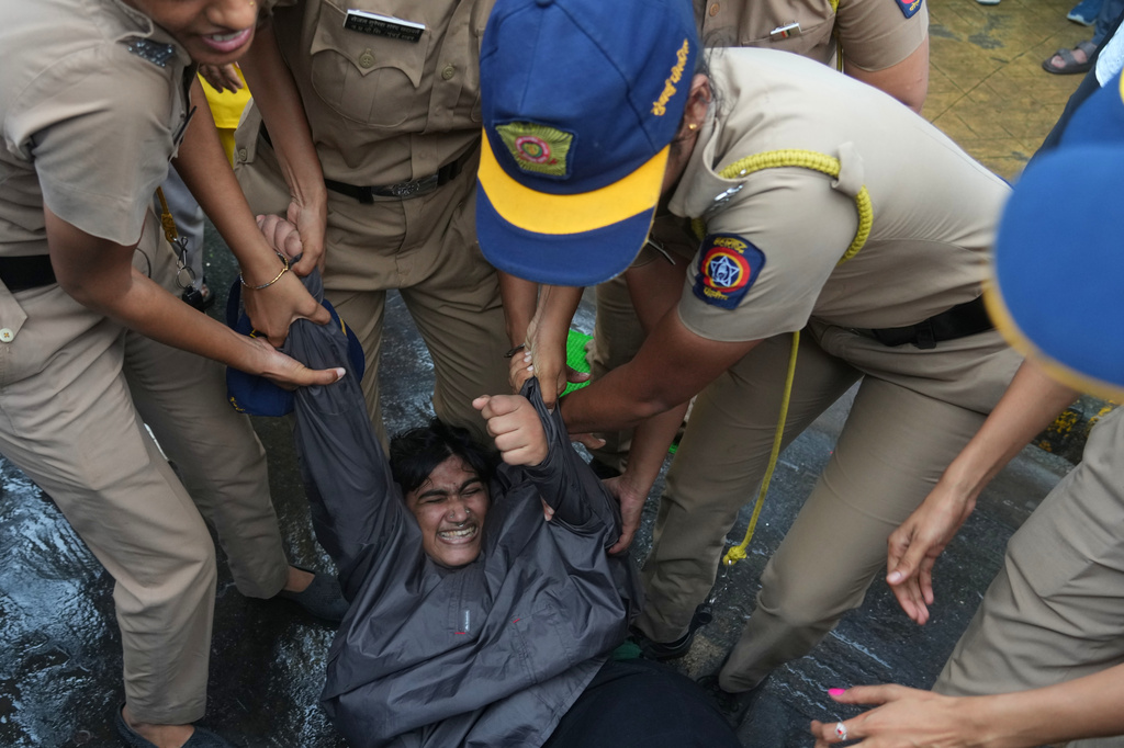 Police officers detain a supporter of the Cockroach Janta Party during a protest demanding the resignation of India's education minister in Mumbai, India, Monday, July 20, 2026.(AP Photo/Rafiq Maqbool)