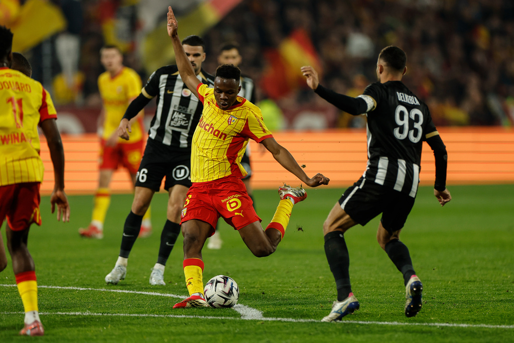 Lens' Sangare Mamadou shoot at goal during the French League One soccer game between Lens and Angers, Friday, March 20, 2026, in Lens, France. (AP Photo/Jean-Francois Badias)
