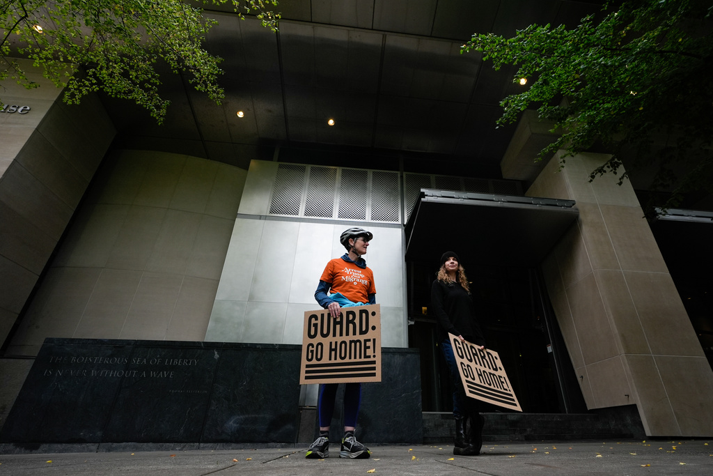 People protest outside a federal courthouse on Friday, Oct. 3, 2025, in Portland, Ore., before a federal court hearing on Oregon's bid to temporarily block President Donald Trump's deployment of the National Guard to Portland is held inside. (AP Photo/Jenny Kane)