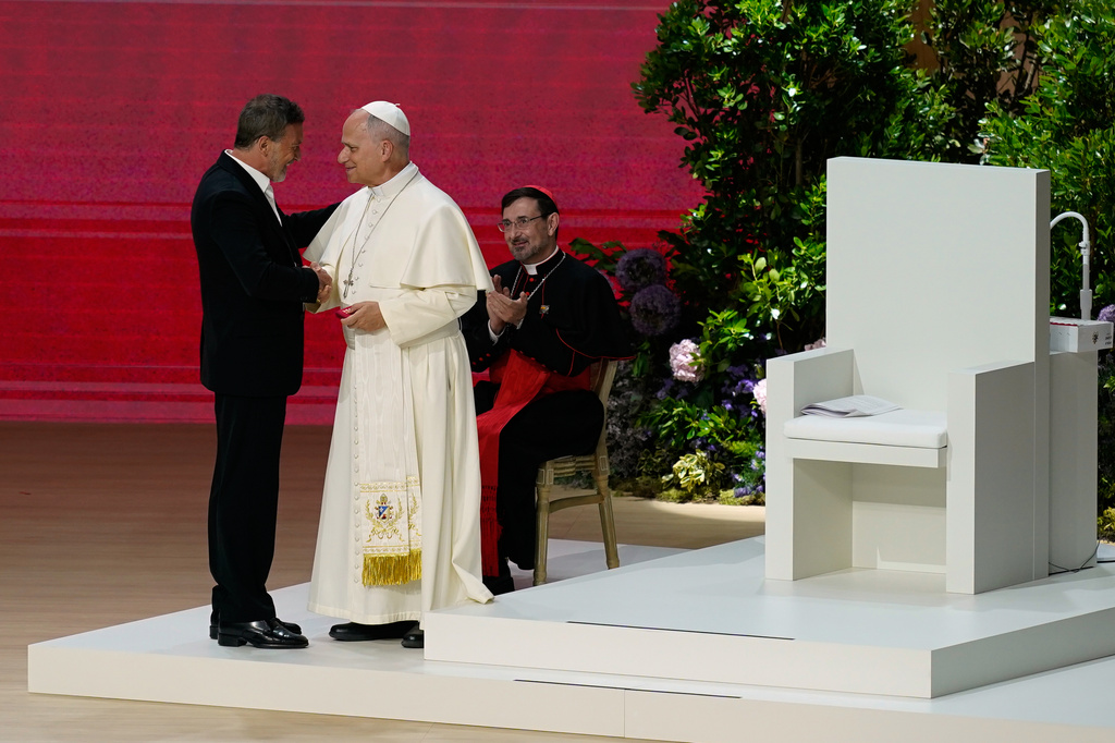 Pope Leo XIV greets Antonio Banderas as he attends the meeting "Building networks with the world of culture, art, economy and sport" at the Movistar Arena in Madrid, Spain, Sunday, June 7, 2026. (AP Photo/Andrea Comas)