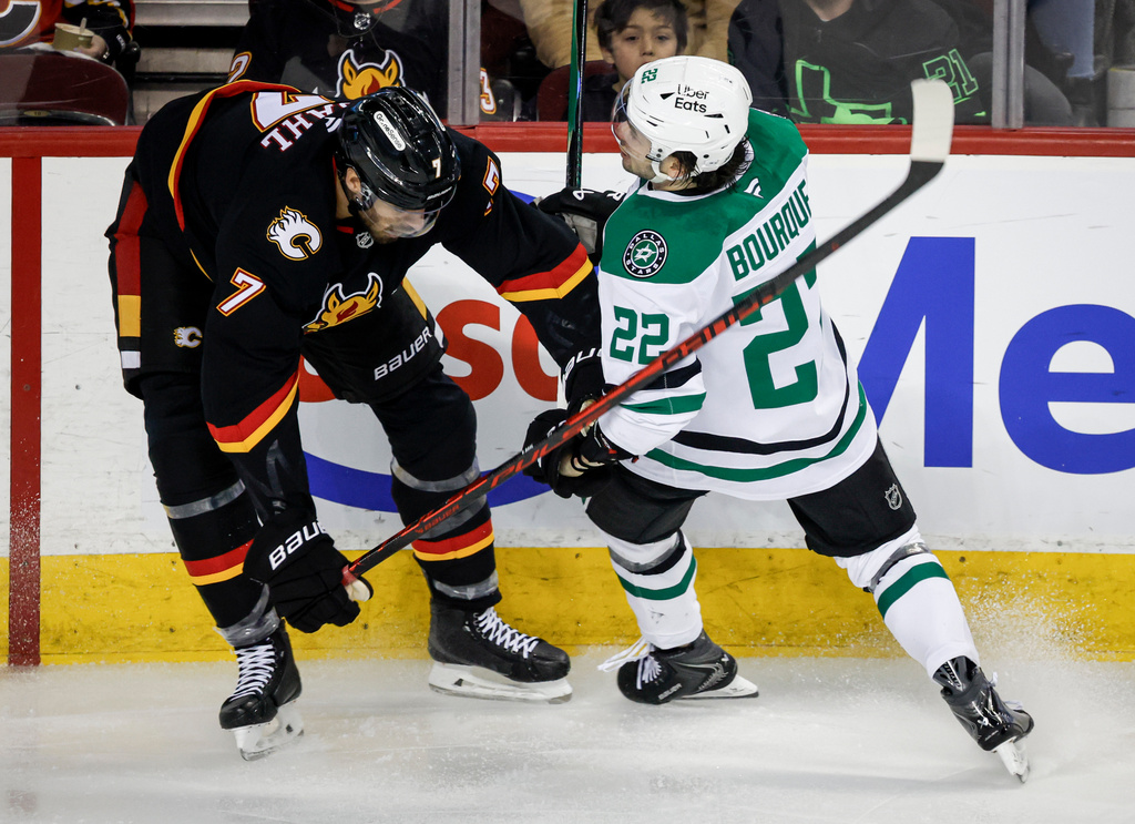 Dallas Stars' Mavrik Bourque, right, is checked by Calgary Flames' Kevin Bahl during the second period of an NHL hockey game in Calgary, Alberta on Tuesday, March 3, 2026. (Jeff McIntosh/The Canadian Press via AP)