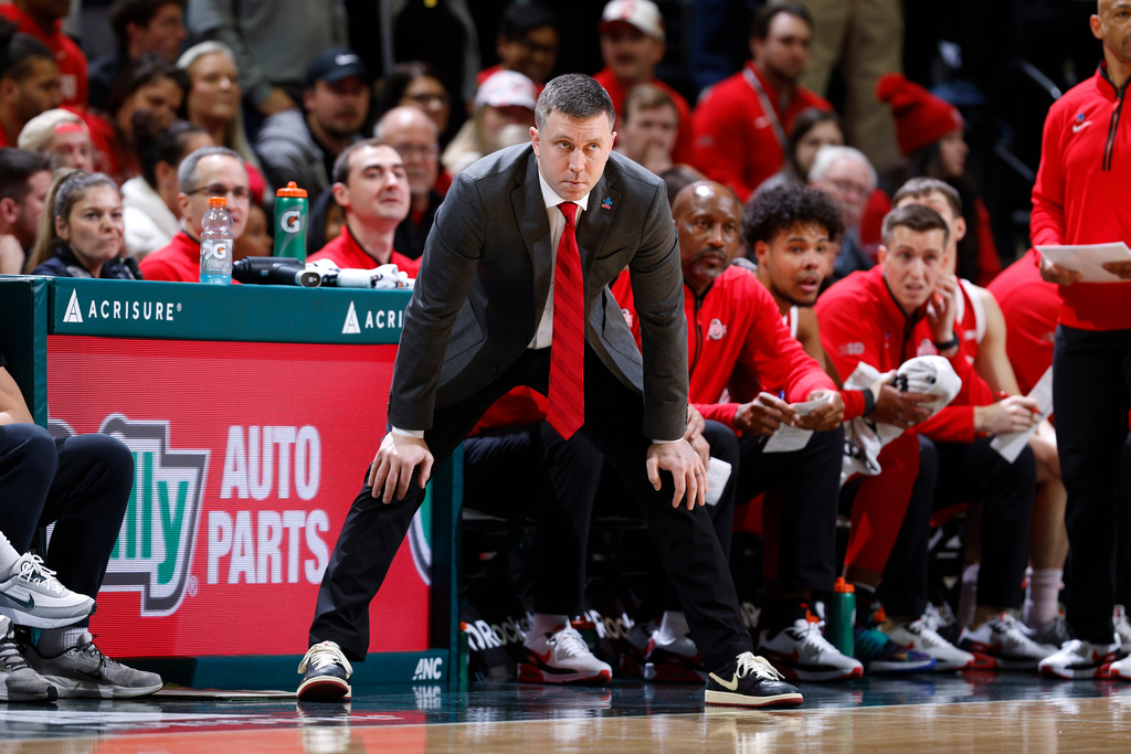 Ohio State coach Jake Diebler, center, watches during the first half of an NCAA college basketball game, Sunday, Feb. 22, 2026, in East Lansing, Mich. (AP Photo/Al Goldis)