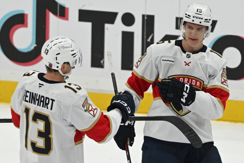 Florida Panthers center Sam Reinhart (13) congratulates Panthers center Anton Lundell after hitting an open net goal during the third period of an NHL hockey game against the Washington Capitals, Saturday, Jan. 17, 2026, in Washington. (AP Photo/John McDonnell)