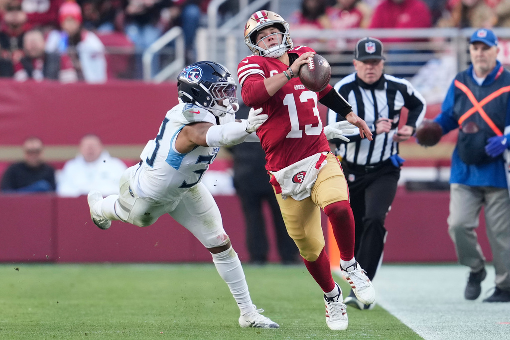 San Francisco 49ers quarterback Brock Purdy (13) runs the ball past Tennessee Titans linebacker Cedric Gray, left, during the second half of an NFL football game, Sunday, Dec. 14, 2025, in Santa Clara, Calif. (AP Photo/Godofredo A. Vásquez)