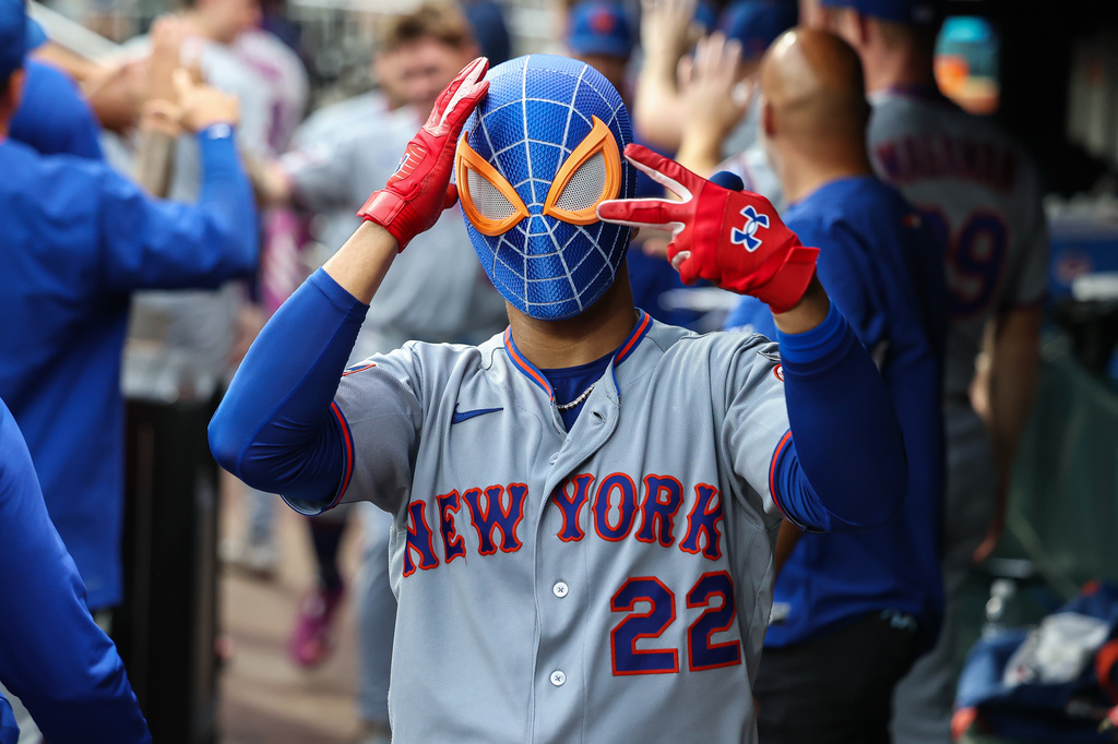 New York Mets' Juan Soto (22) reacts in the dugout with a Spiderman mask after hitting a tying two-run home run in the third inning of a baseball game against the Atlanta Braves, Friday, July 3, 2026, in Atlanta. (AP Photo/Colin Hubbard)