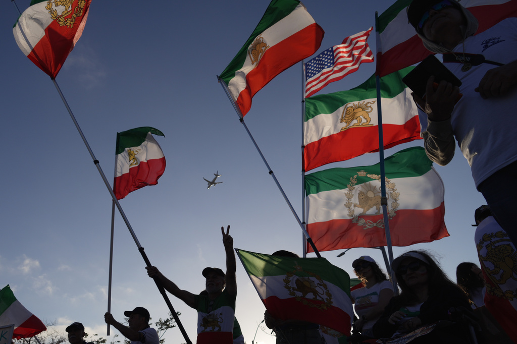 People wave pre-revolutionary Iranian flags during a protest outside Los Angeles Stadium before the World Cup Group G soccer match between Iran and New Zealand in Inglewood, Calif., near Los Angeles, Monday, June 15, 2026. (AP Photo/Ty ONeil)