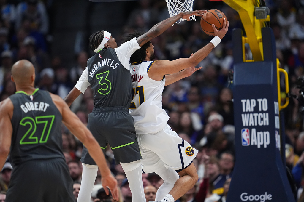 Minnesota Timberwolves forward Jaden McDaniels, left, tries to block a shot by Denver Nuggets guard Jamal Murray in the second half in Game 1 of a first-round NBA playoffs basketball series, Saturday, April 18, 2026, in Denver. (AP Photo/David Zalubowski)
