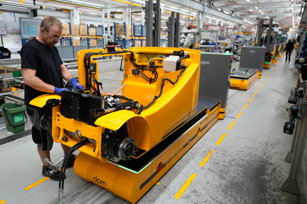 Employees at forklift and warehouse manufacturer Jungheinrich work on the assembly line in Moosburg, Germany, Tuesday, Aug. 25, 2026. (AP Photo/Matthias Schrader)