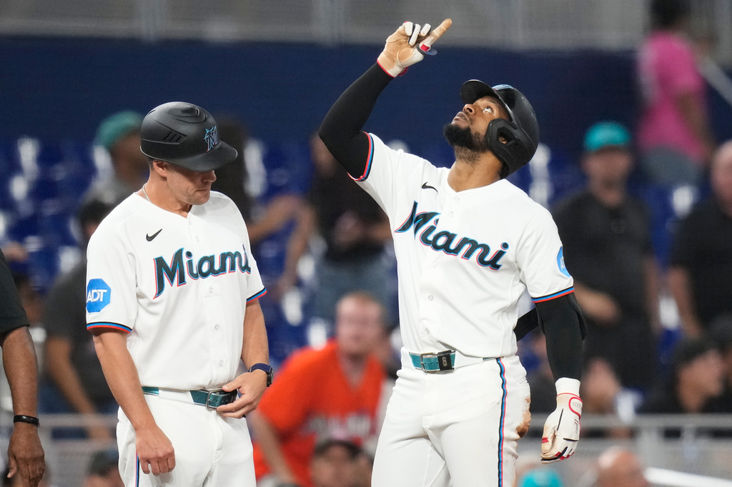 Miami Marlins' Otto Lopez, right, reacts after hitting a triple to break a franchise record with the most hits before the All Star break during the fourth inning of a baseball game against the Seattle Mariners, Thursday, July 9, 2026, in Miami. (AP Photo/Lynne Sladky)