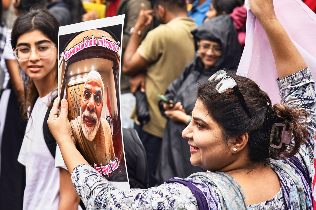 A protestor holds a placard with a portrait of Indian Prime Minister Narendra Modi and the text loosely translated as "Open the Door Friends, I Bring Bad Times" during a demonstration demanding educational reforms as part of the Cockroach Janta Party's ongoing protest movement in Pune, India, Friday, July 24, 2026. (AP Photo)