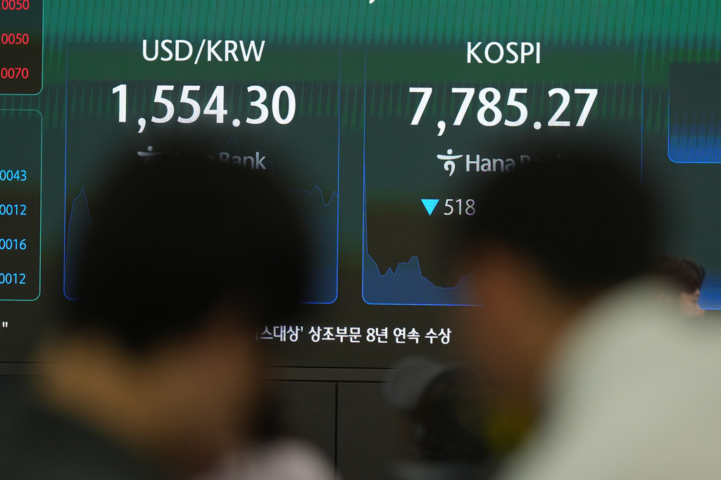 Members of media film near the screens showing the Korea Composite Stock Price Index (KOSPI) and the foreign exchange rate between U.S. dollar and South Korean won at a dealing room of Hana Bank in Seoul, South Korea, Thursday, July 2, 2026. (AP Photo/Lee Jin-man)