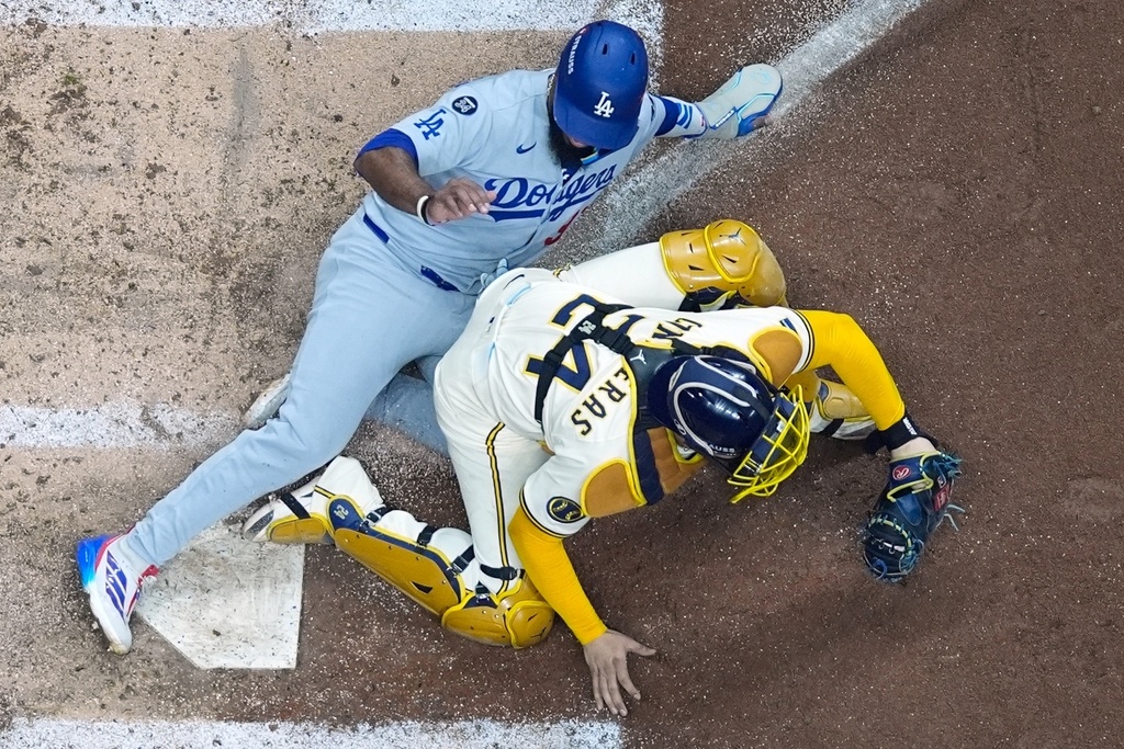 Los Angeles Dodgers' Teoscar Hernández is out at home as Milwaukee Brewers catcher William Contreras takes the throw during the fourth inning of Game 1 of baseball's National League Championship Series Monday, Oct. 13, 2025, in Milwaukee. (AP Photo/Morry Gash)