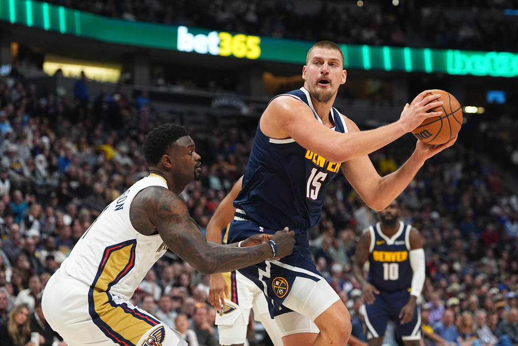 Denver Nuggets center Nikola Jokic (15) drives to the basket as New Orleans Pelicans forward Zion Williamson defends in the first half of an NBA basketball game Wednesday, Oct. 29, 2025, in Denver. (AP Photo/David Zalubowski)
