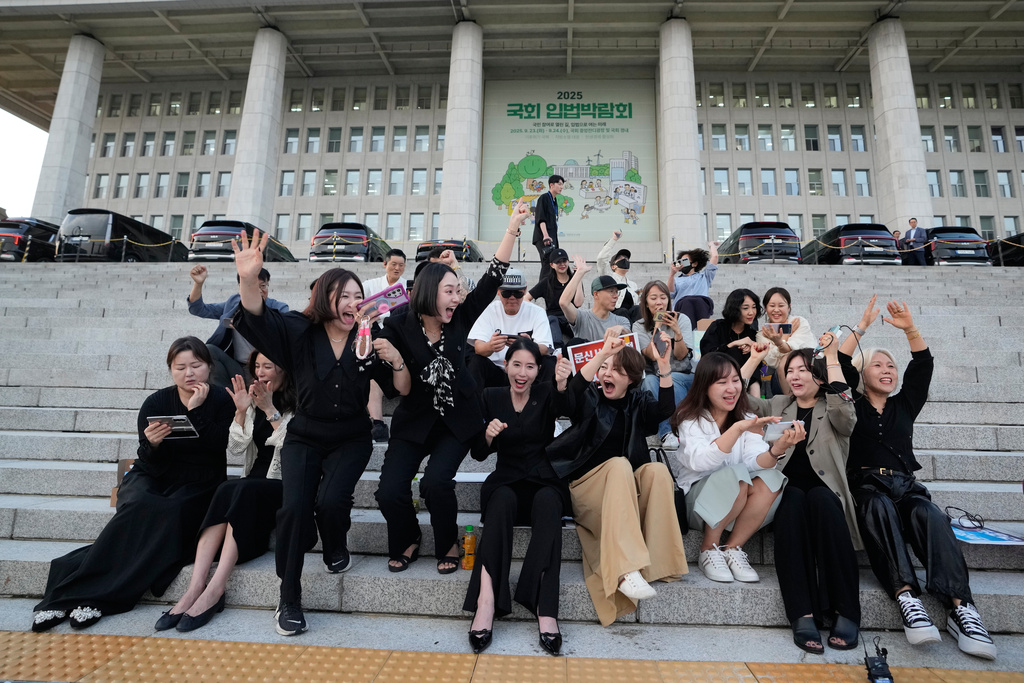 Members of the Korea Tattoo Federation celebrate after hearing the news that parliament passed a bill that would allow non-medical personnel to give tattoos outside the National Assembly in Seoul, South Korea, Thursday, Sept. 25, 2025. (AP Photo/Ahn Young-joon)